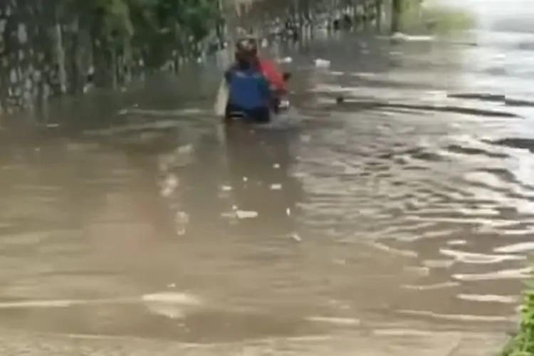 Pengemudi Motor Terobos Banjir, Netizen Malah Salfok Sama Penumpangnya
