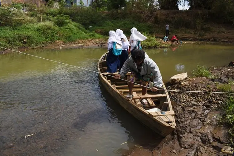 Foto: Anak-anak Sekolah Seberangi Sungai Citarum dengan Rakit