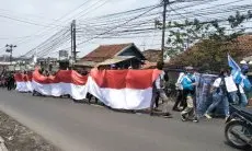 Gelar Long March, Ribuan Buruh KBB Bentangkan Bendera Merah Putih Raksasa di Jalan
